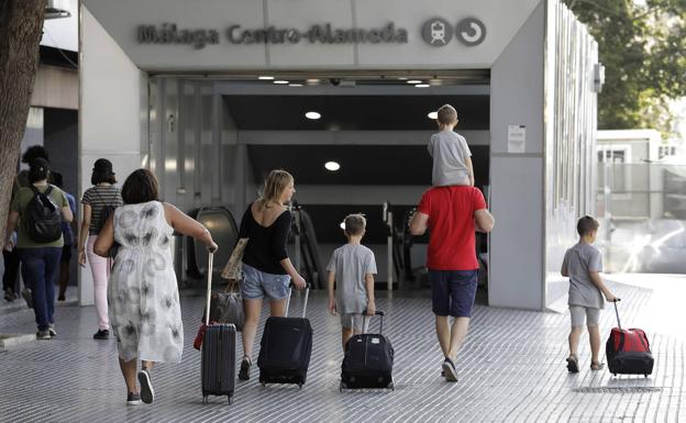Turistas que acaban de llegar en tren se disponen a continuar viaje en el Cercanías hacia la Costa. 