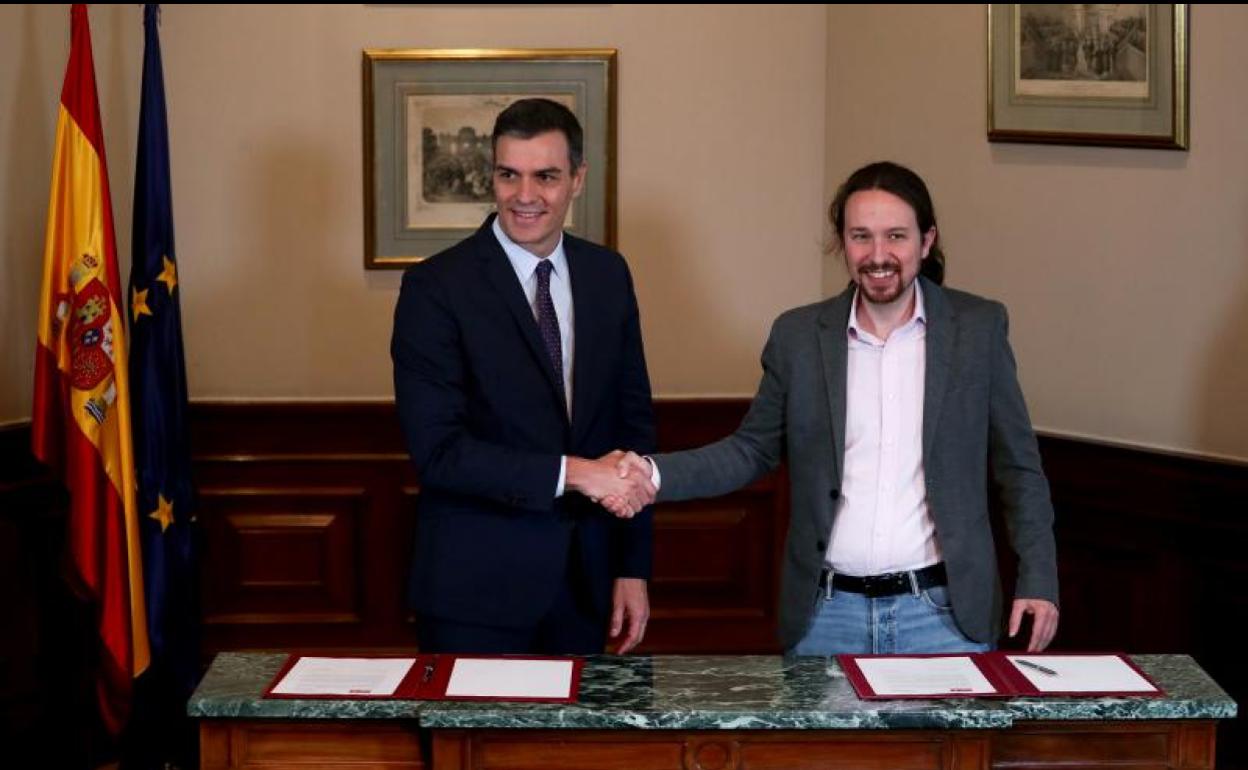 Abrazo de Pedro Sánchez y Pablo Iglesias, ayer, tras la firma del preacuerdo.