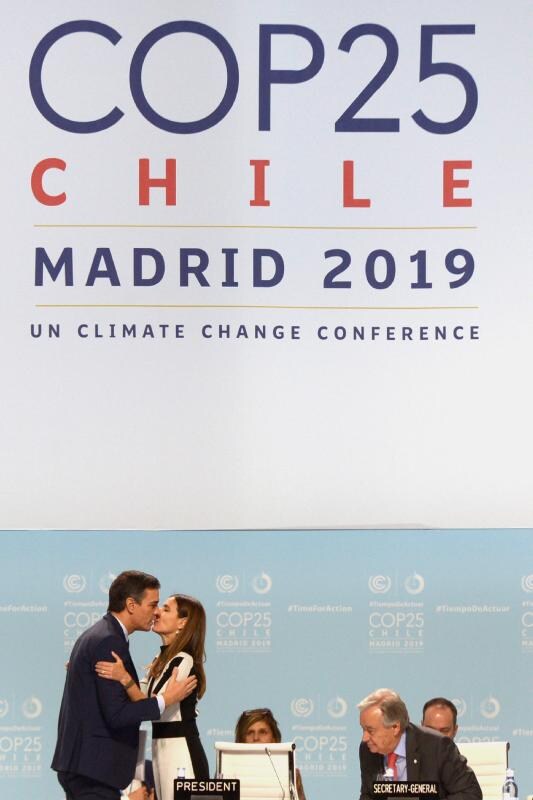 La presidenta de la COP25 y ministra de Medio Ambiente chilena, Carolina Schmidt, besa al presidente español Pedro Sánchez.