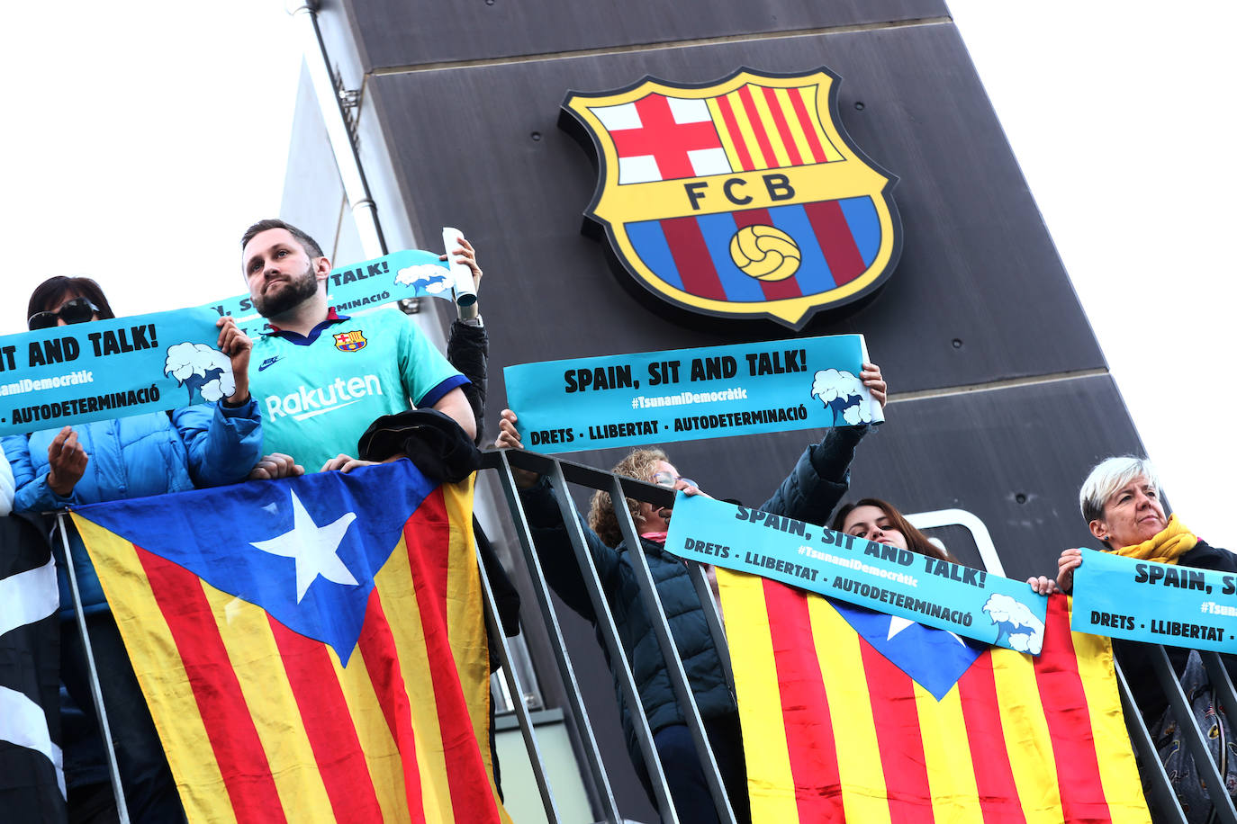Manifestantes se suben a las vallas que rodean el Camp Nou. 