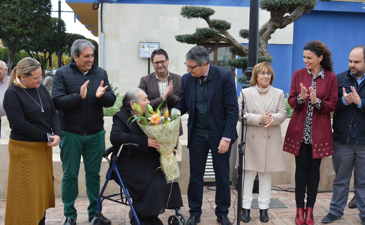 El alcalde entregando flores la viuda. 