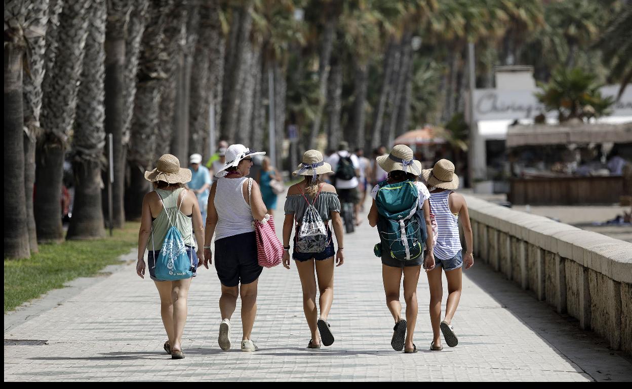 Gente paseando por el paseo marítimo de Málaga.