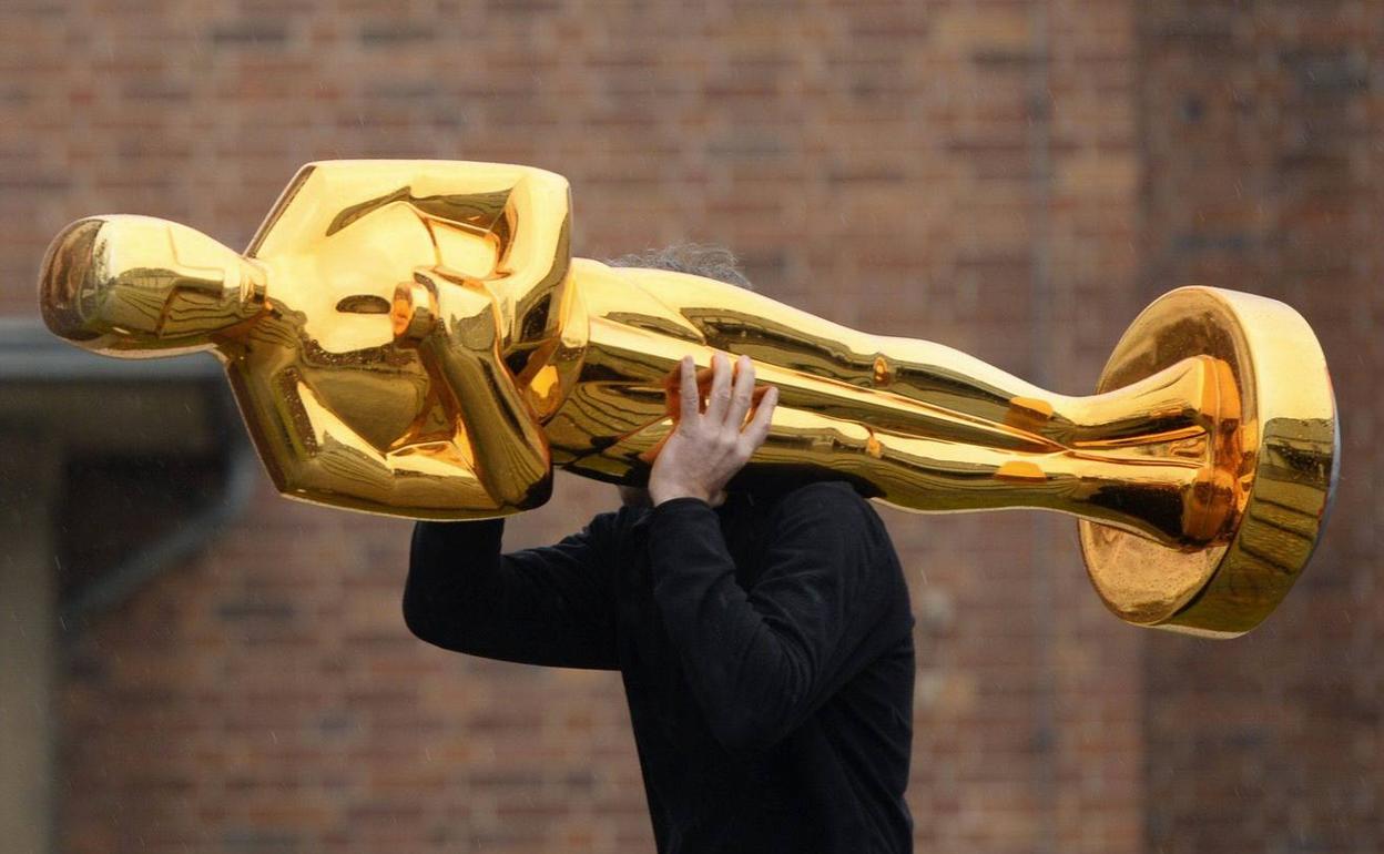 Trabajador trasladando una escultura de un Oscar, durante un acto promocional (archivo).