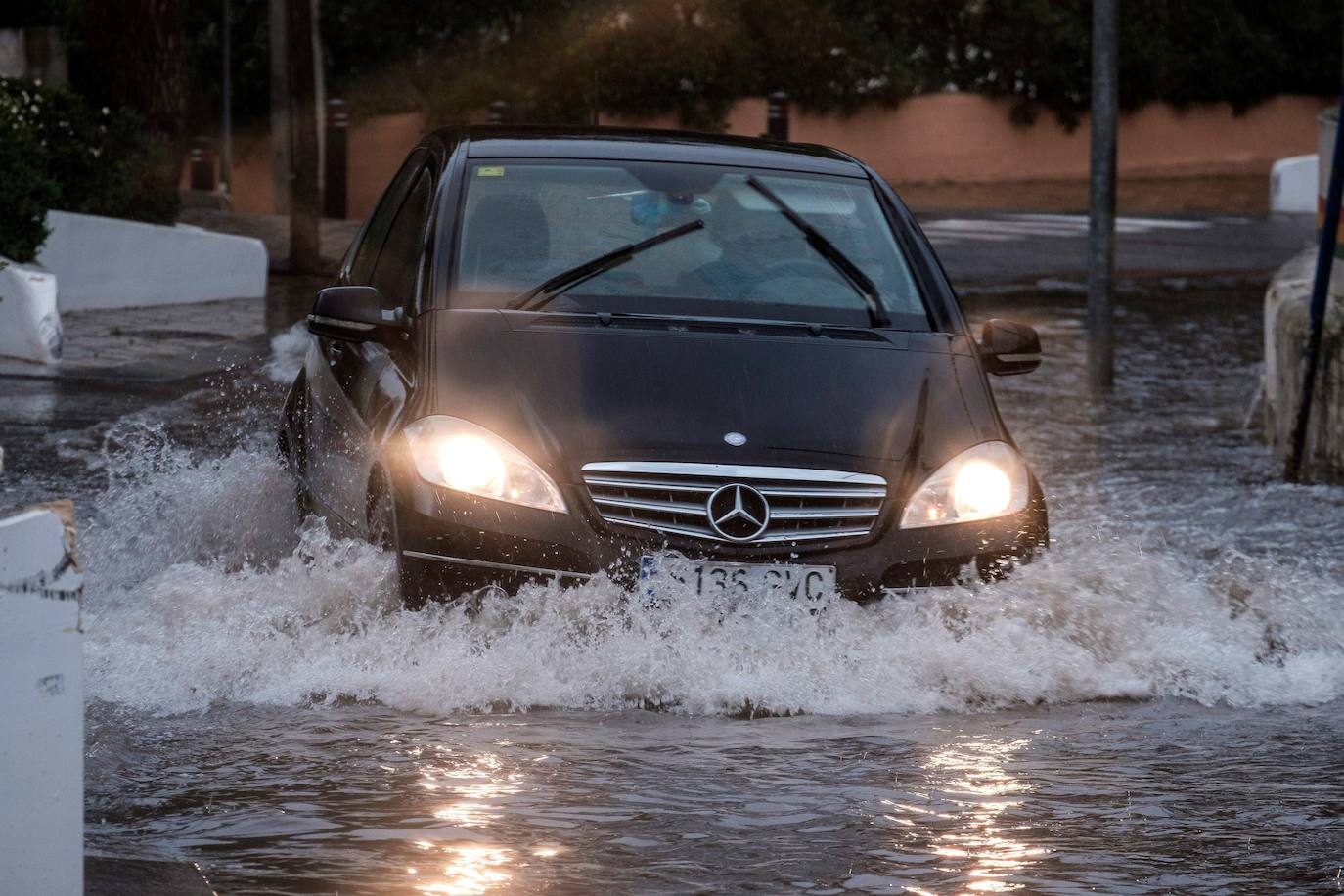 Un coche transita una calle inundada de Cala de Bou (Ibiza) 