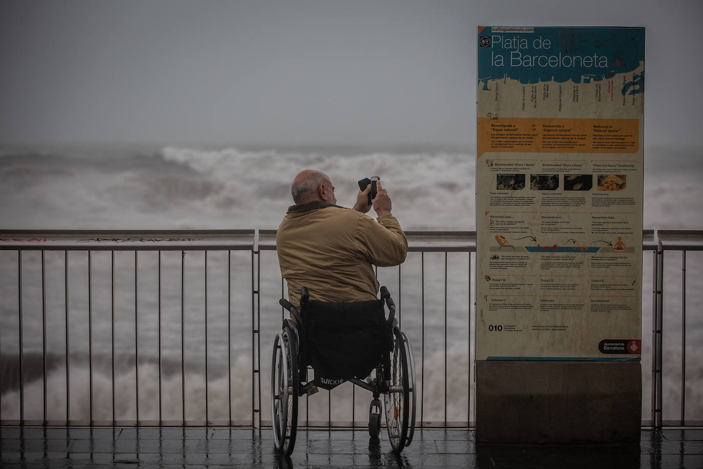 Un hombre hace una foto en el paseo marítimo de Barcelona