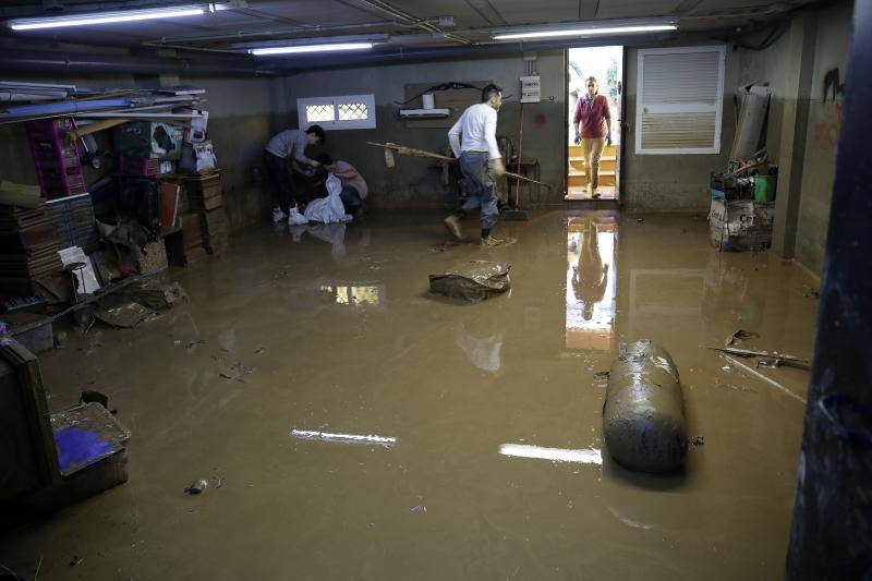 Vecinos y comerciantes de Campanillas tratan de recuperar la normalidad tras la fuerte tormenta que se ensañó con esta barriada de Málaga. 