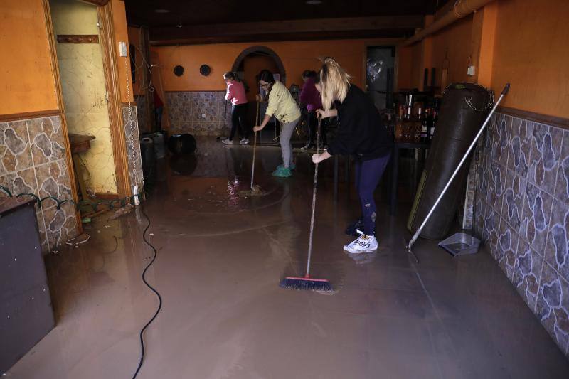 Vecinos y comerciantes de Campanillas tratan de recuperar la normalidad tras la fuerte tormenta que se ensañó con esta barriada de Málaga. 