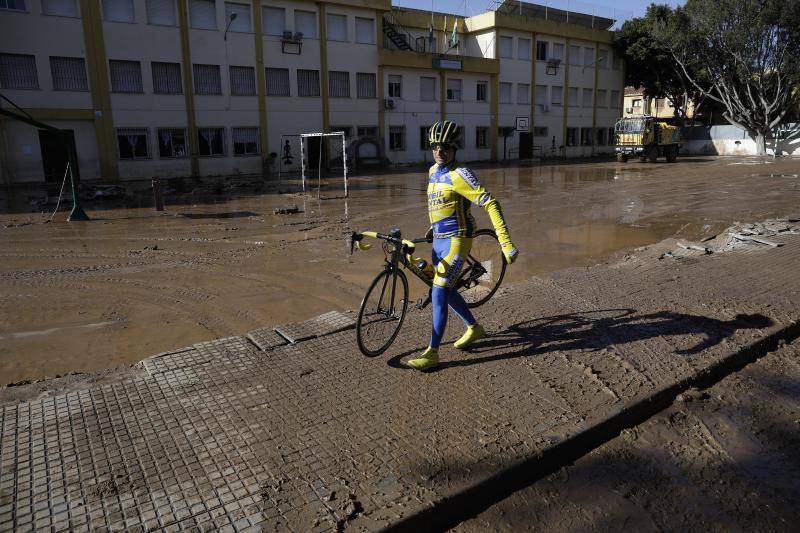 Vecinos y comerciantes de Campanillas tratan de recuperar la normalidad tras la fuerte tormenta que se ensañó con esta barriada de Málaga. 