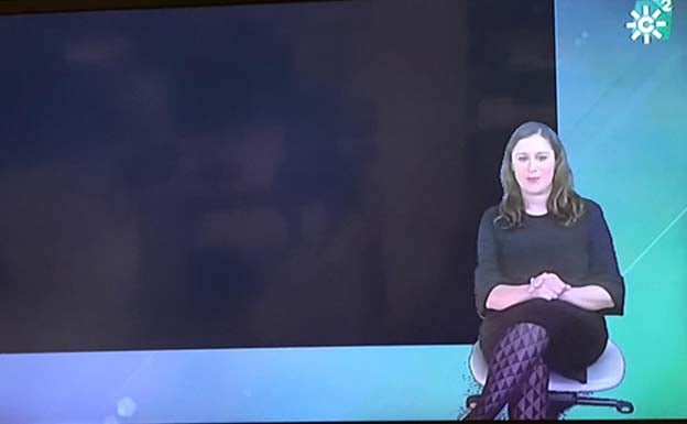 Una intérprete de lengua de signos de Canal Sur 2, sobre el fondo negro de la emisión 