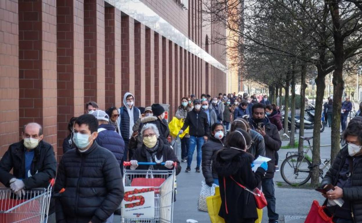 Gente con mascarilla en un supermercado de Milán 