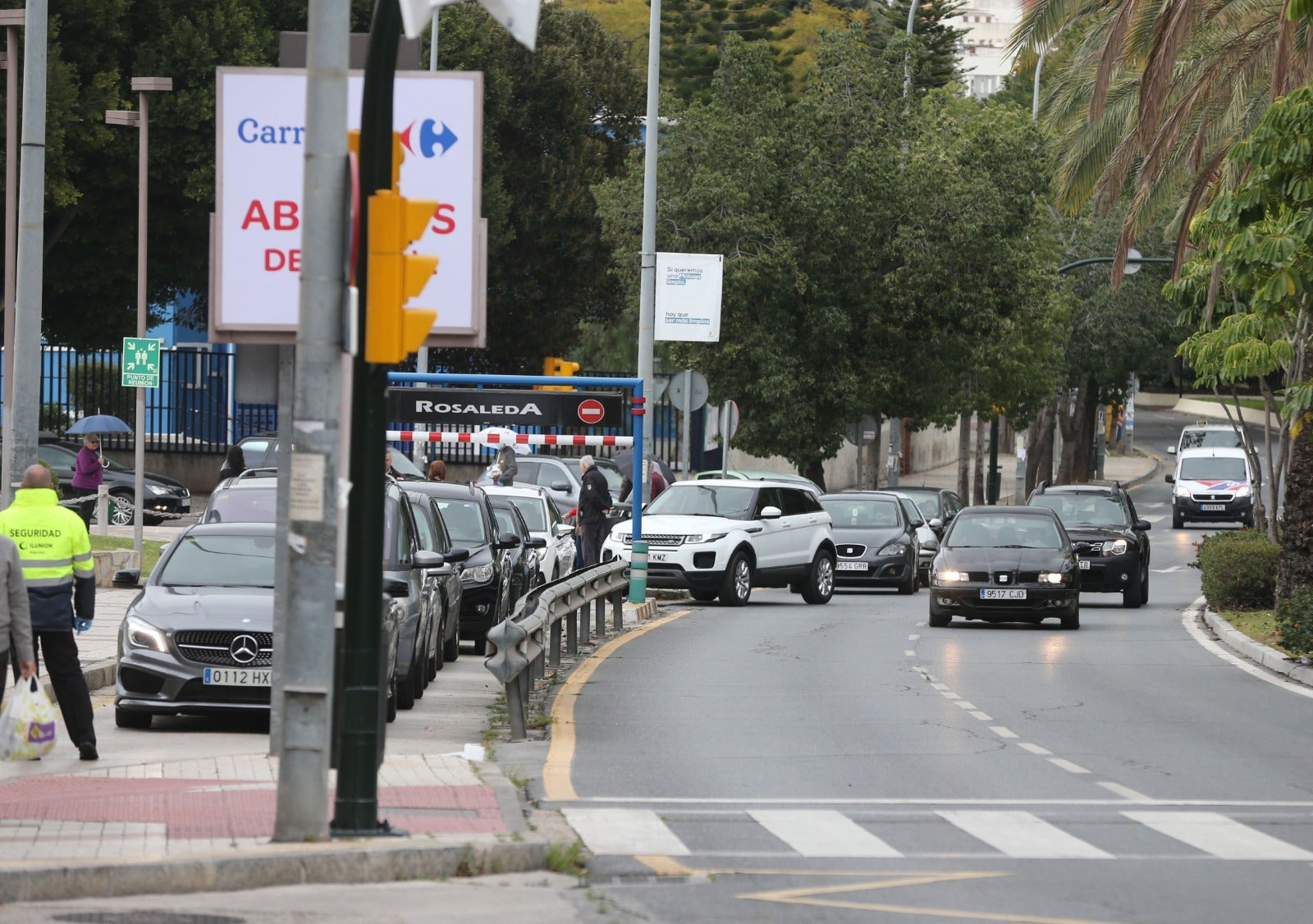 Ciudadanos hacen cola para acceder al centro comercial Rosaleda, en Málaga capital.