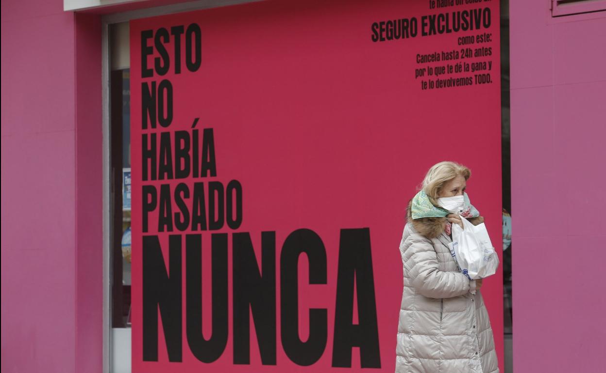 Una mujer pasea con una mascarilla. 