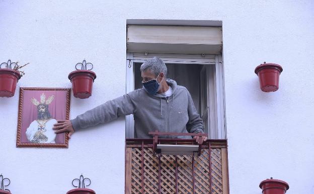 Un vecino de la Trinidad, acaricia un azulejo con la imagen de Jesús Cautivo. 