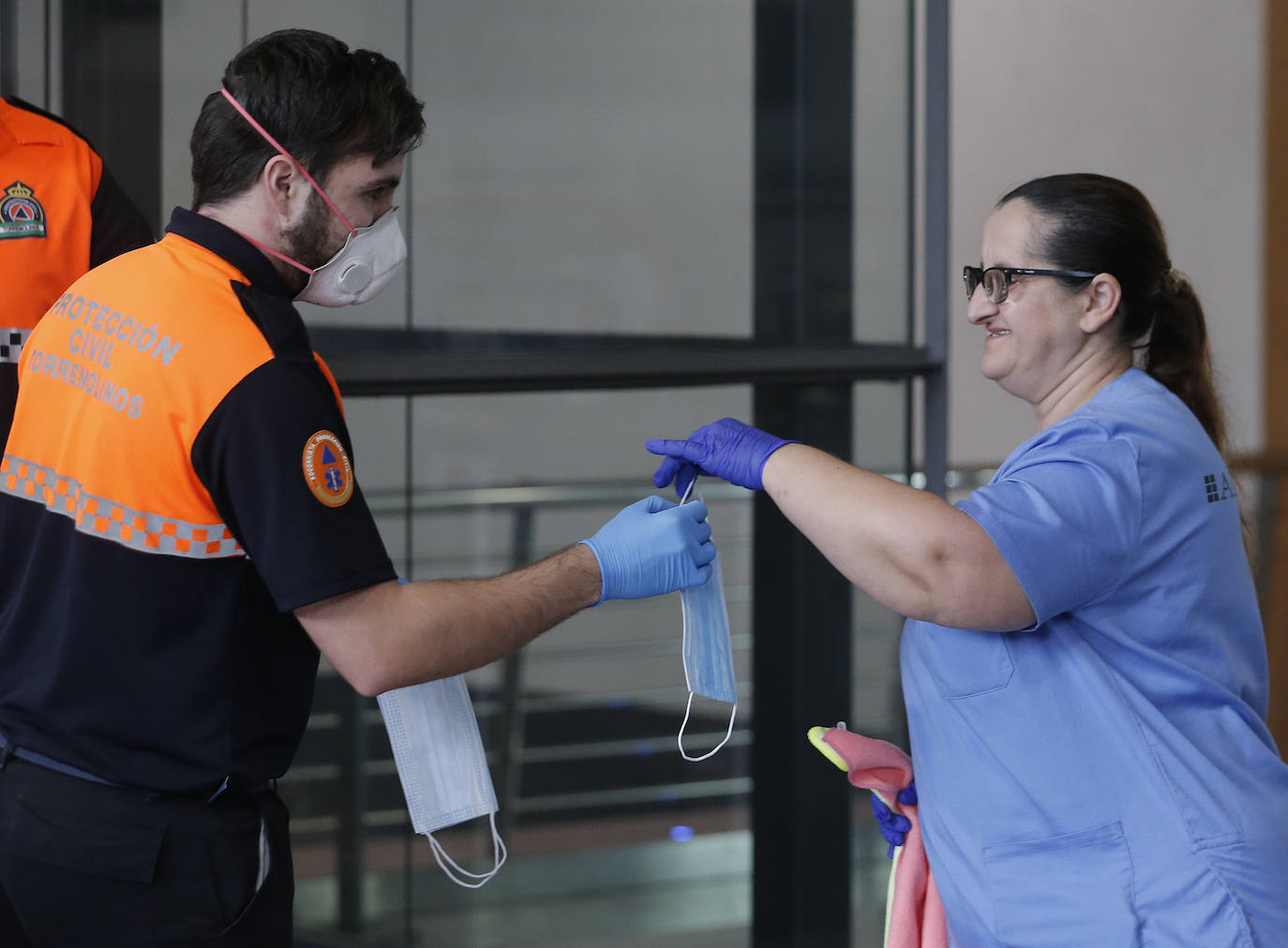 El estado de alarma deja estampas inéditas. Protección Civil comienza en Málaga el reparto de mascarillas a los trabajadores en los transportes públicos.