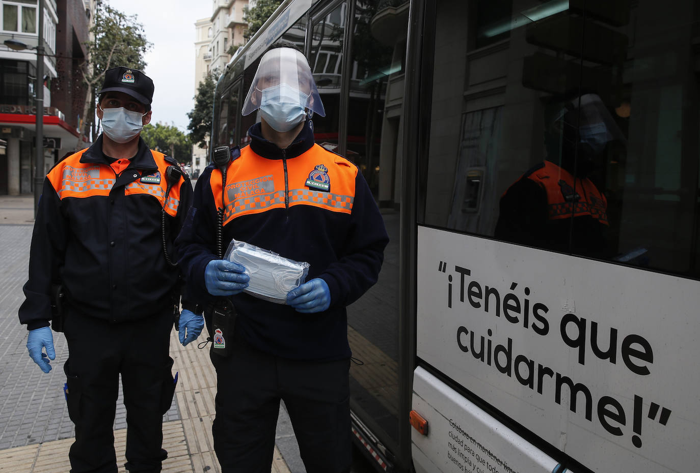 El estado de alarma deja estampas inéditas. Protección Civil comienza en Málaga el reparto de mascarillas a los trabajadores en los transportes públicos.