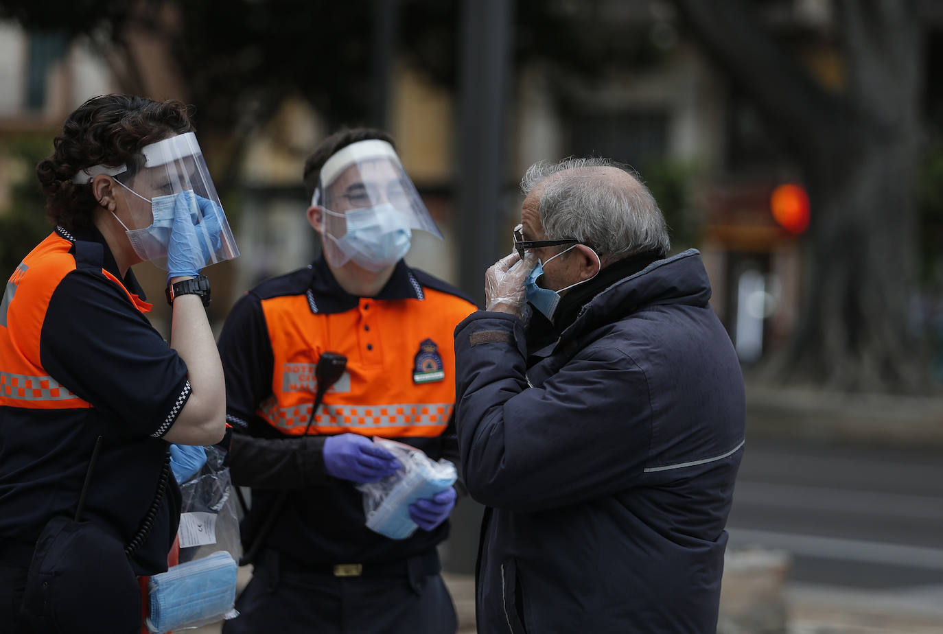 El estado de alarma deja estampas inéditas. Protección Civil comienza en Málaga el reparto de mascarillas a los trabajadores en los transportes públicos.