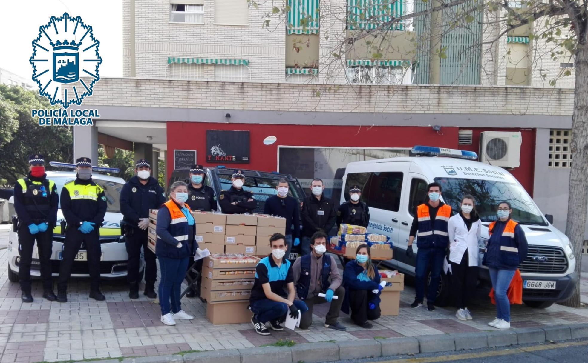 Voluntarios y agentes participan en la entrega del material solidario. 