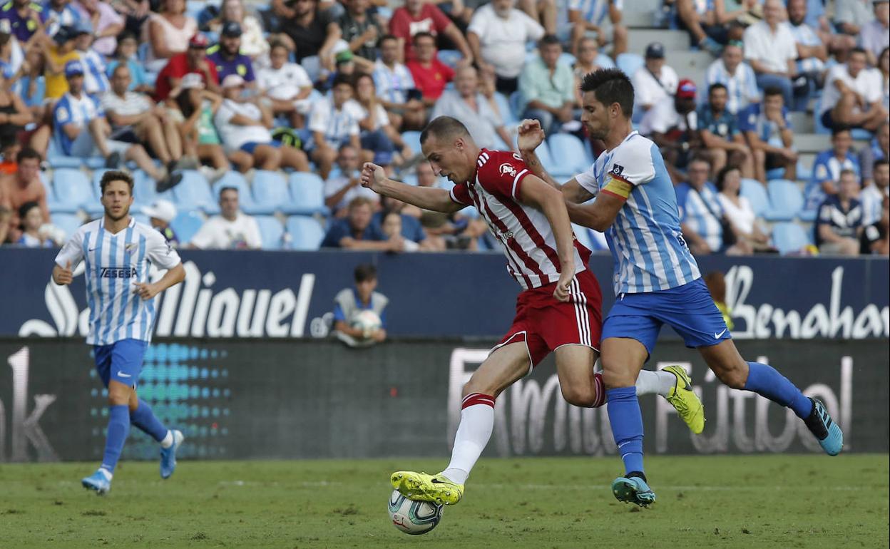 Adrián trata de frenar a Petrovic en el duelo ante el Almería en La Rosaleda. 