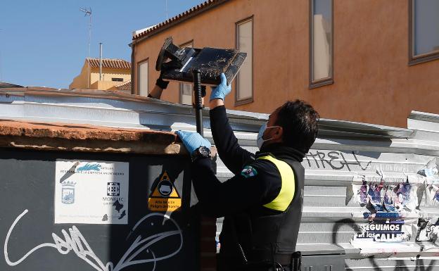 Uno de los agentes recoge parte del equipo informático que el detenido estaba preparando para llevarse a su domicilio. 