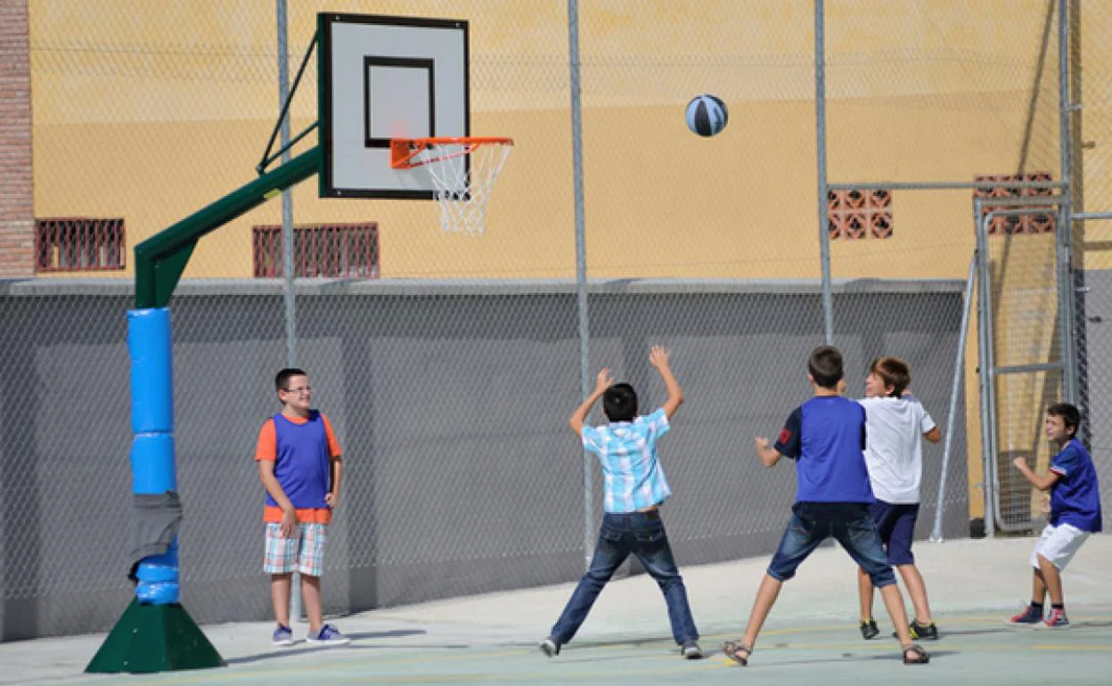 Niños hacen deporte en el patio de un colegio durante las actividades de verano. 