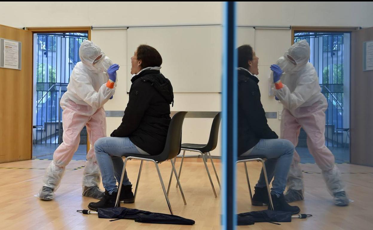 Un sanitario realiza una prueba del coronavirus a un vecino de una localidad próxima a Munich.