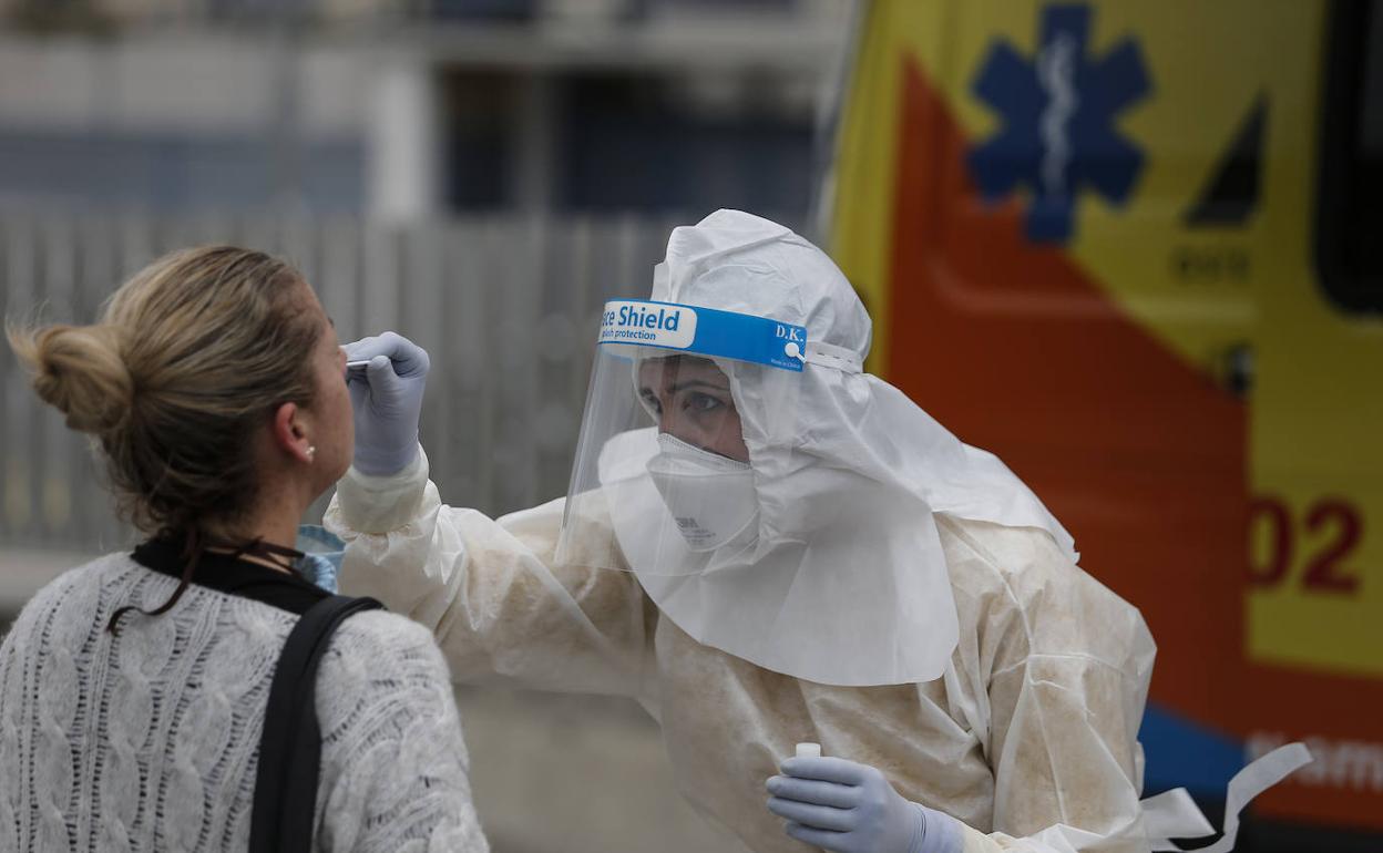 Un sanitario toma una muestra para poder hacer una PCR. 