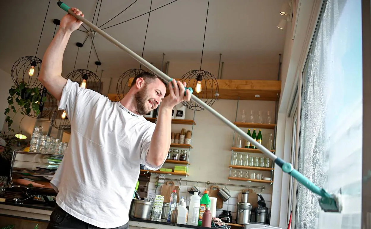 Un hombre desinfecta un café en Colonia para su reapertura.