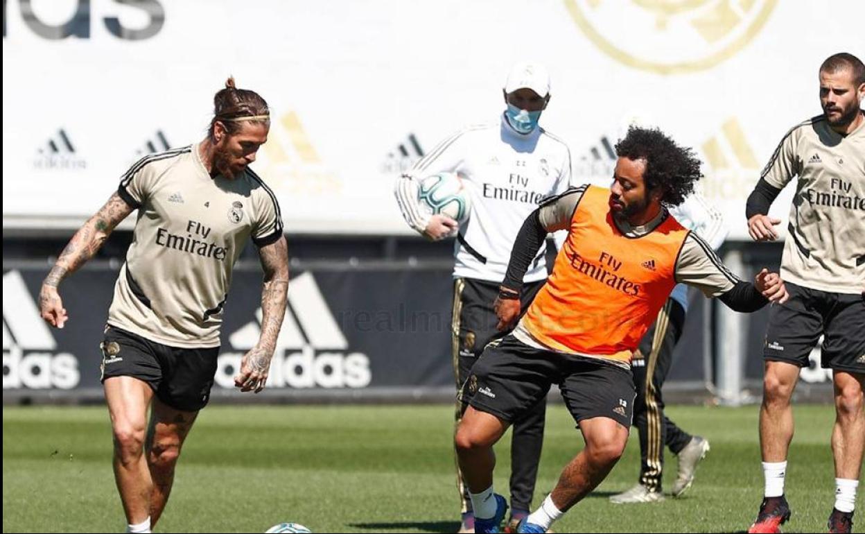 Zidane, con mascarilla, observa el entrenamiento de sus jugadores en Valdebebas.