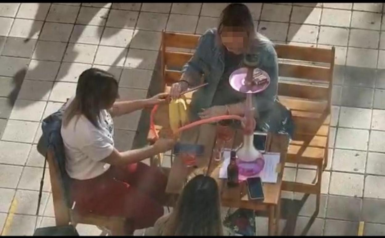 Imagen tomada en la fase 1 en la que dos jóvenes comparten una cachimba. 