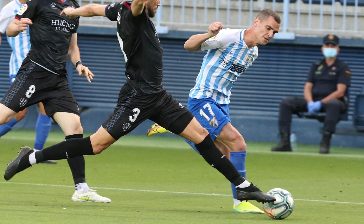 Buenacasa intenta prosperar en una jugada en el Málaga 1-3 Huesca del viernes 12 de junio en LaLiga.