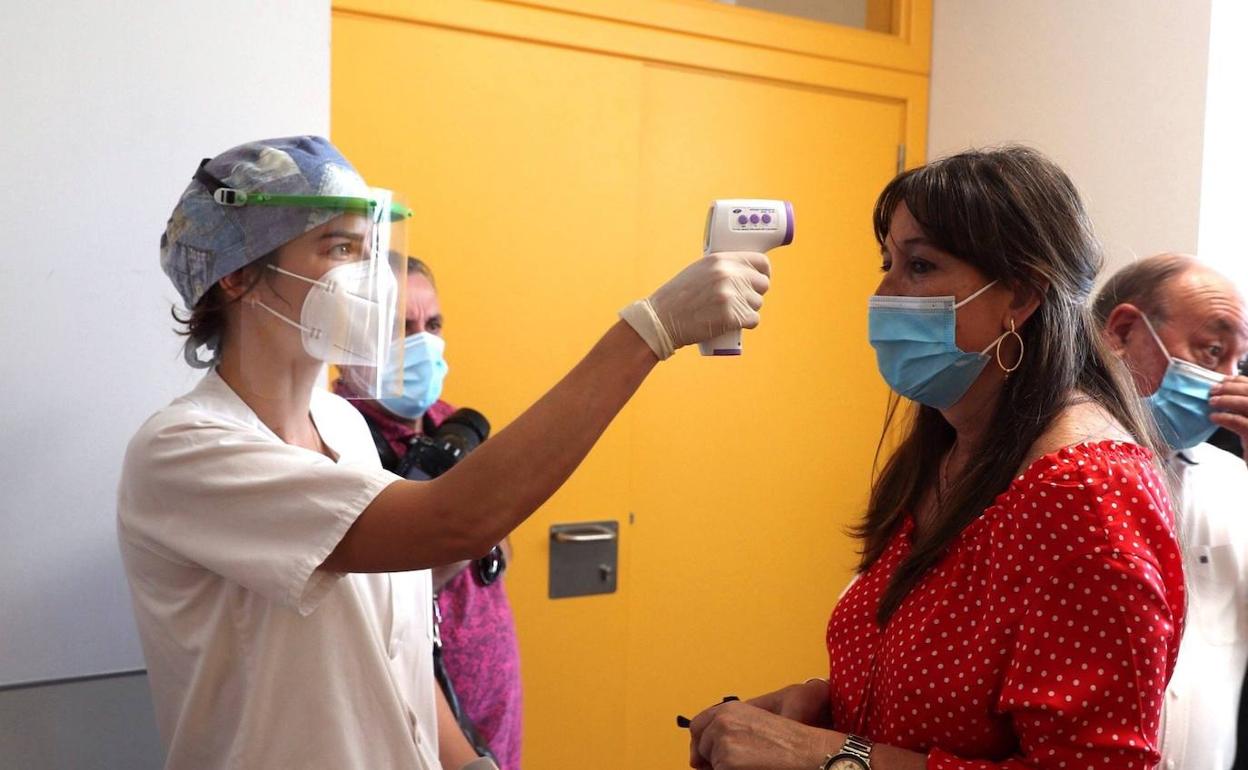 Una sanitaria del Centro de Salud de Binéfar (Huesca) toma la temperatura a la consejera de Sanidad del Gobierno de Aragón, Sira Repollés