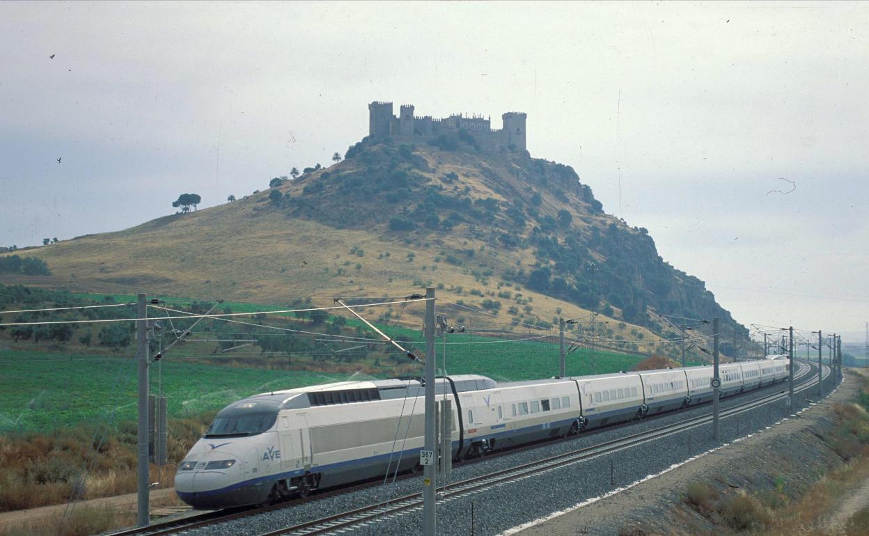 Un tren AVE circula frente al castillo de Almodóvar del Río. 