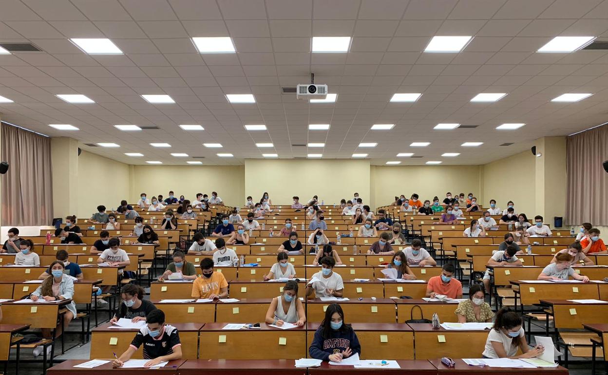 Alumnos con mascarilla esperan el inicio del examen de Historia de España, en un aula de la Facultad de Medicina. 