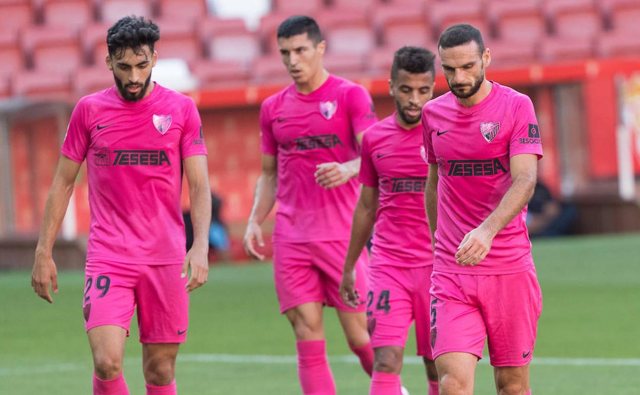 Juagadores del Málaga, cabizbajos tras uno de los goles del Sporting.