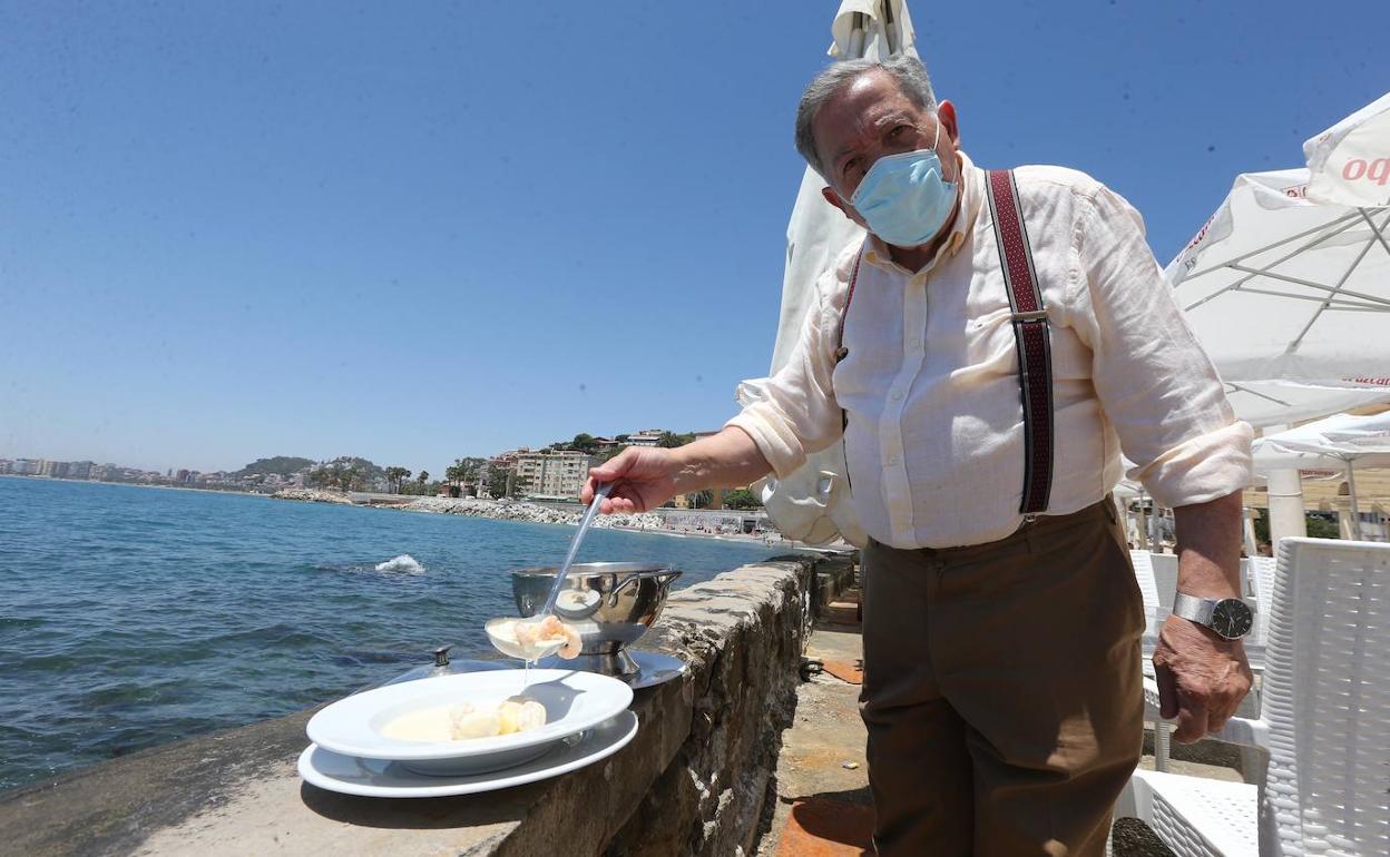 Adolfo Jaime sirve un plato de su popular gazpachuelo en el malecón del Balneario de los Baños del Carmen. 