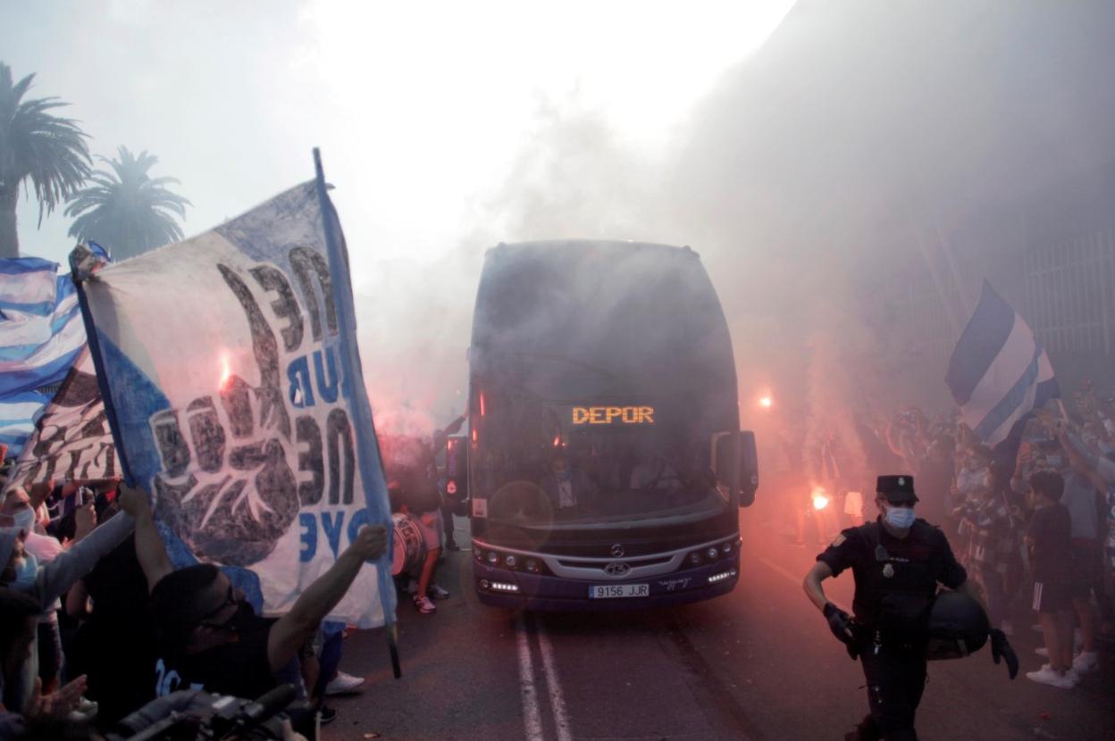 Aficionados del Deportivo aplauden el lunes la llegada del autobús de su equipo a Riazor, donde iba a disputarse el partido que quedó aplazado. efe