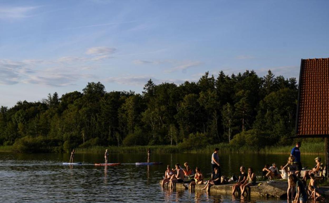 La gente disfruta de la cálida noche de verano en el lago Starnberg cerca de Muensing (Alemania) 