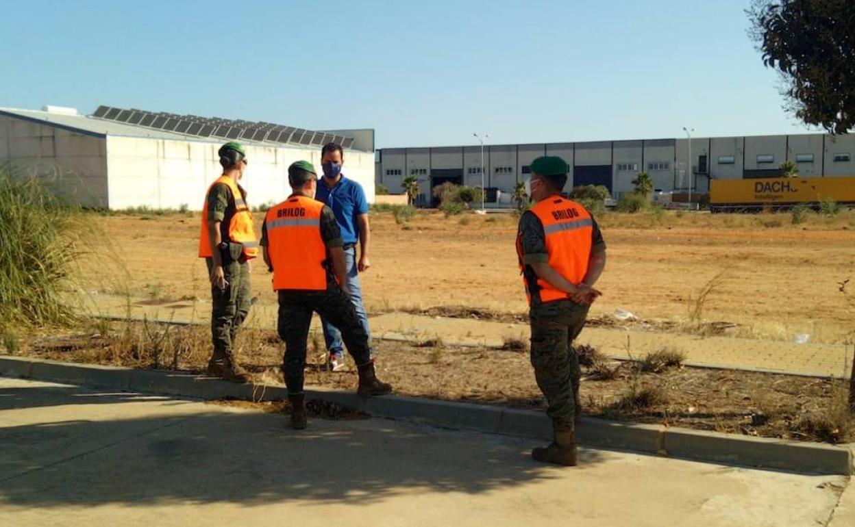 Militares y autoridades locales inspeccionan los terrenos para el campamento. 