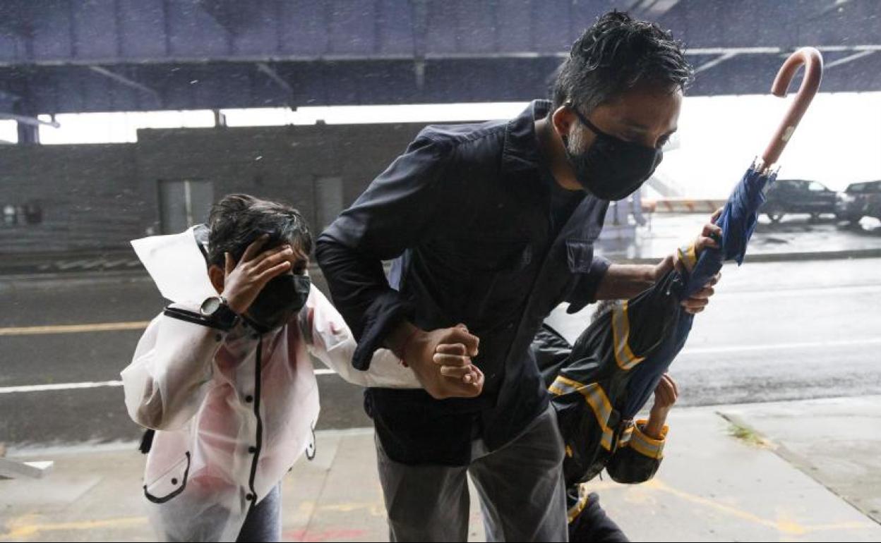 Un padre se resguarda de la tormenta junto a sus hijos en Manhattan, Nueva York.