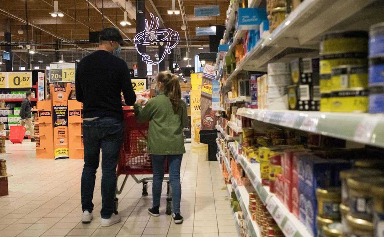 Las familias restringen su presupuesto y llenan la cesta de la compra de productos básicos. 