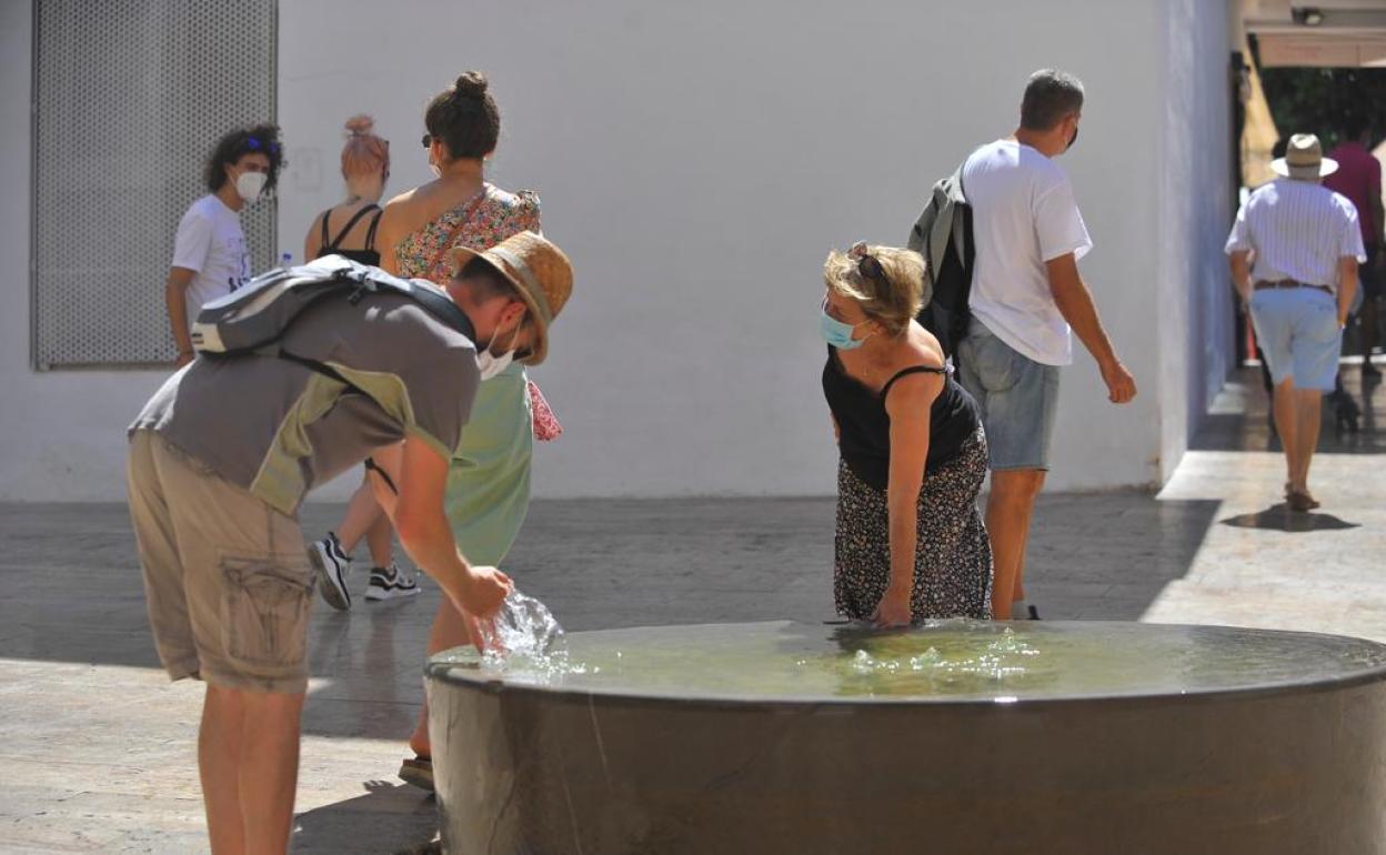 Varias personas se refrescan en el Centro durante esta jornada de intenso calor-