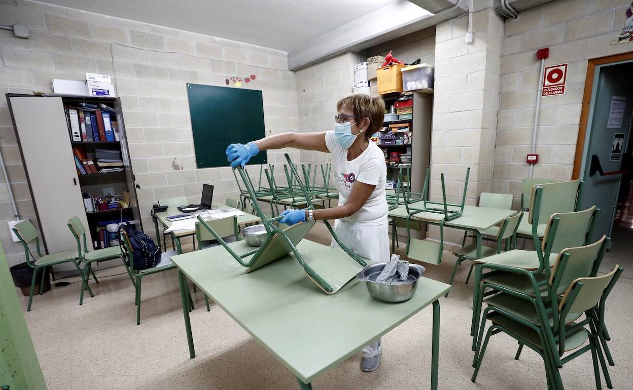 Una empleada prepara el comedor de un colegio. 
