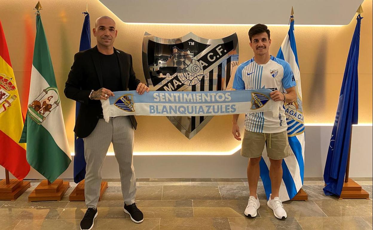 El director deportivo, Manolo Gaspar, junto al nuevo jugador malaguista Matos, en las oficinas del club y con una bufanda del equipo. 