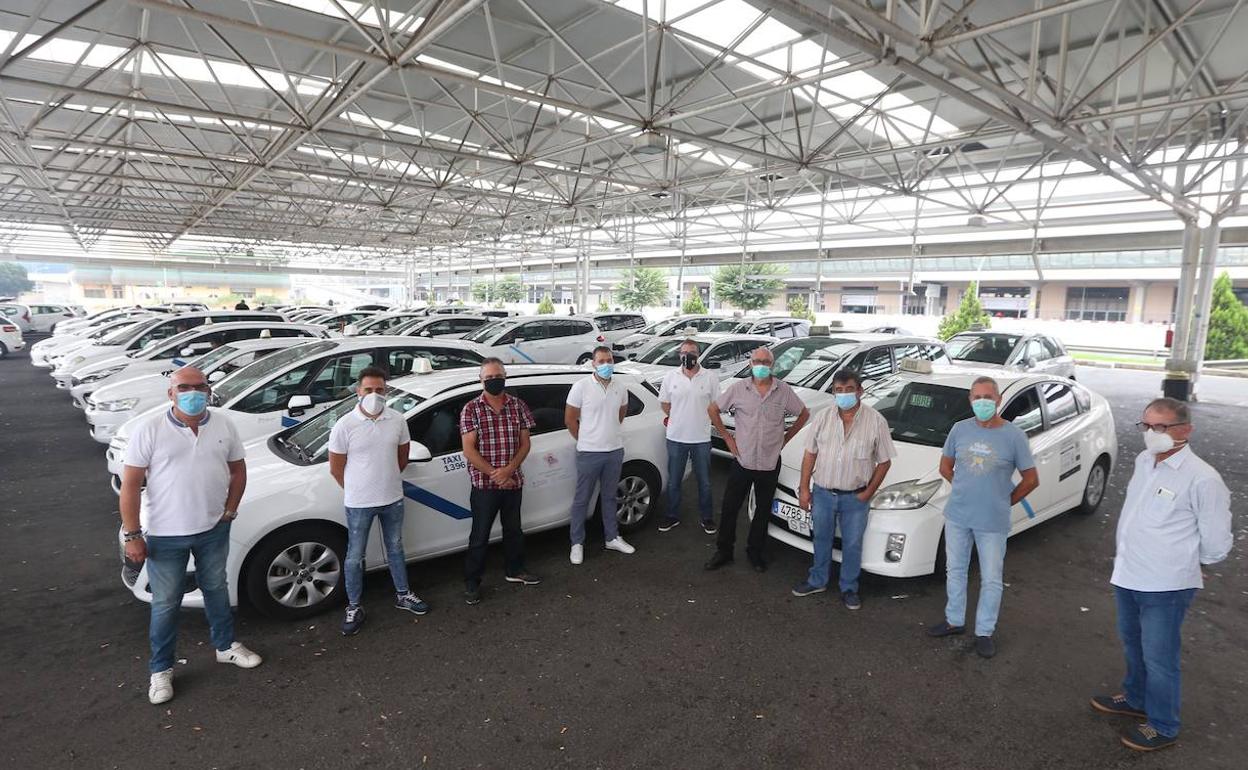 Un grupo de taxistas malagueños en la bolsa de vehículos del aeropuerto a la espera de clientes. 