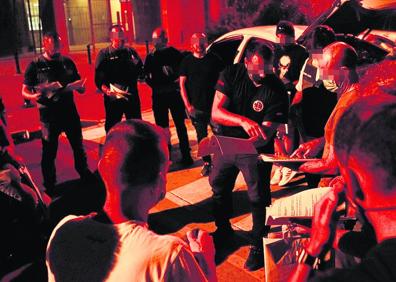 Imagen secundaria 1 - Por sorpresa: Un agente se lleva a la mujer de un sospechoso mientras sus compañeros aseguran el interior. Todo a punto: Los mandos reparten las fichas de los objetivos en una explanada situada a las afueras de Algeciras. Efectuarán 40 registros en tres tandas, muchos simultáneos para reducir la capacidad de reacción del narco.Soluciones imaginativas: Narcoembarcadero camuflado tras una fachada corredera en la playa de Puente Mayorga. 