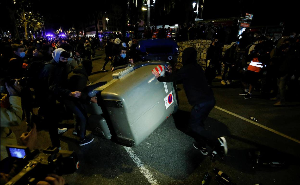 Varios miembros de los CDR tiran contenedores de basura en las calles de Barcelona anoche durante sus protestas.