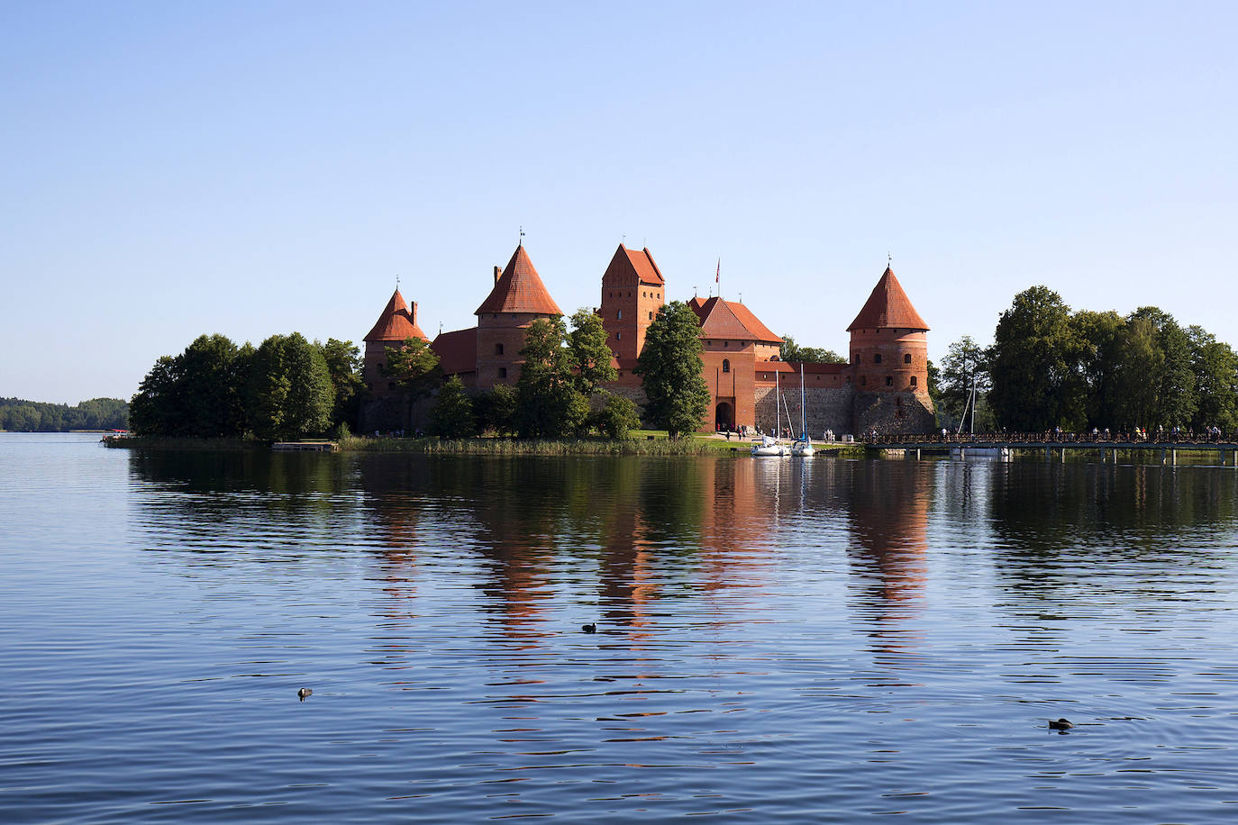 Castillo de Trakai (Lituania). Ubicada en un idílico paisaje en la isla de Trakai esta pintoresca estructura del siglo XIV fue uno de los principales centros del Gran Ducado de Lituania, que se disfrutó como residencia de verano. Hoy el castillo consta de dos: el original, muy pequeño, situado a un lado del lago, y un segundo, erigido en siglos posteriores, ubicado en medio de las aguas. Citado por los entusiastas de la arquitectura como una verdadera encarnación del estilo gótico, el castillo ofrecía una serie de galerías de madera, paneles de vidrieras, murales y pasadizos secretos, que los visitantes pueden ver en el museo oficial del castillo, según la web Jetcost.es