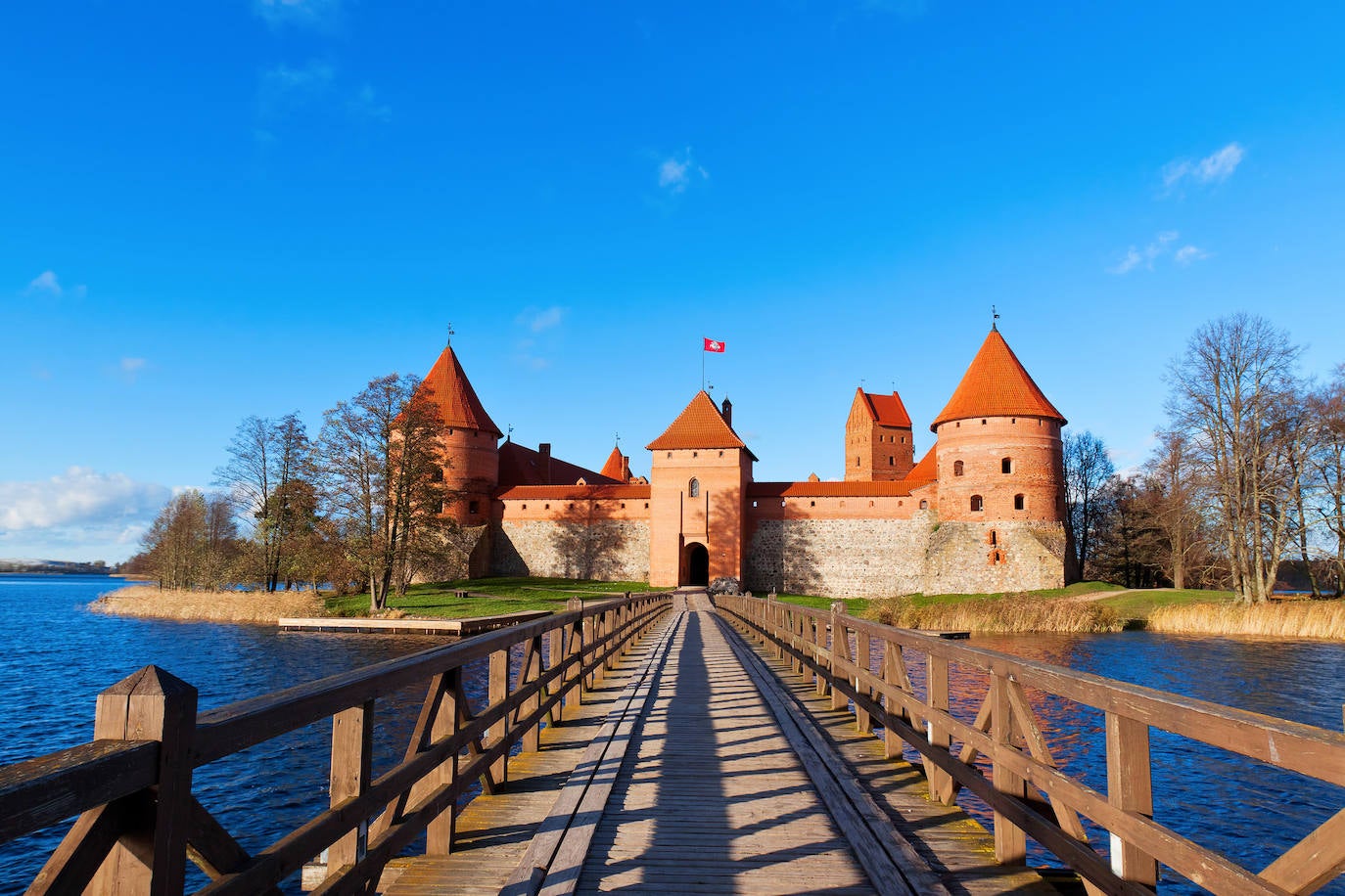 Castillo de Trakai (Lituania). Ubicada en un idílico paisaje en la isla de Trakai esta pintoresca estructura del siglo XIV fue uno de los principales centros del Gran Ducado de Lituania, que se disfrutó como residencia de verano. Hoy el castillo consta de dos: el original, muy pequeño, situado a un lado del lago, y un segundo, erigido en siglos posteriores, ubicado en medio de las aguas. Citado por los entusiastas de la arquitectura como una verdadera encarnación del estilo gótico, el castillo ofrecía una serie de galerías de madera, paneles de vidrieras, murales y pasadizos secretos, que los visitantes pueden ver en el museo oficial del castillo, según la web Jetcost.es