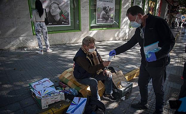 Imagen principal - Arriba, Jesús ofrece mascarillas de repuesto a Rafael, que vive en un cajero automático. Abajo, a la izquierda, Gabriel le enseña su DNI a Estefanía. Al lado, la unidad de calle supervisa el lugar donde viven varias personas, debajo del Puente de Arroyo Jaboneros 