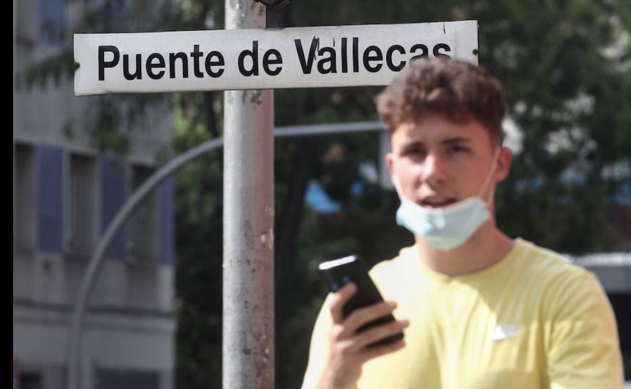 Un joven pasea cerca del metro de Puente de Vallecas, en Madrid.